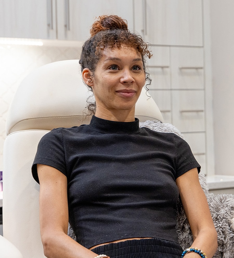 Woman sitting in a modern, stylish setting.