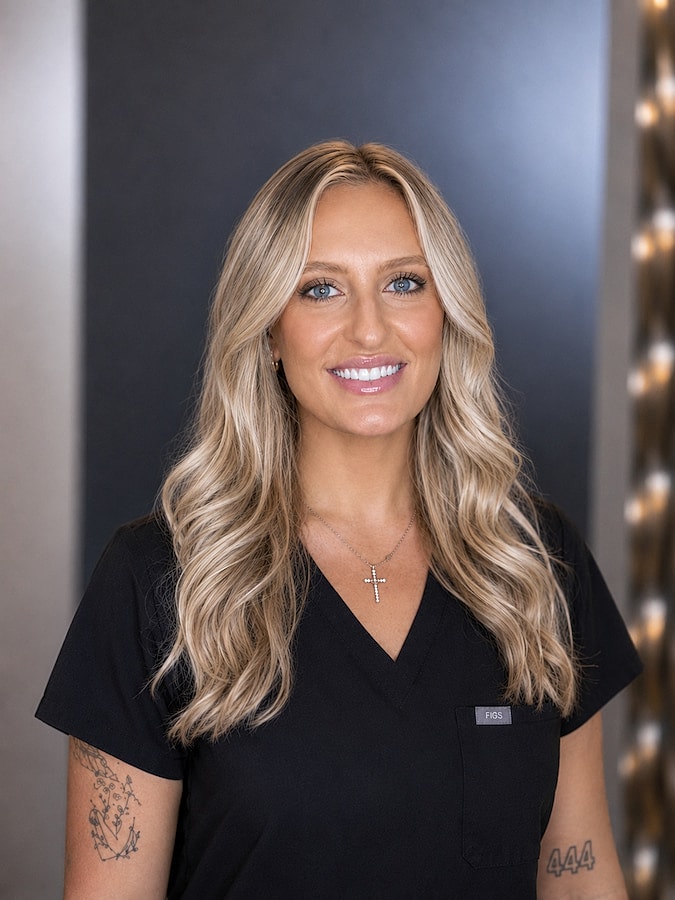 Smiling woman in black scrubs portrait.