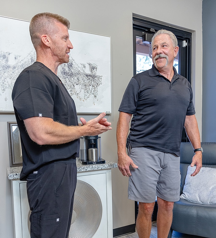 Two men talking in a modern office setting.